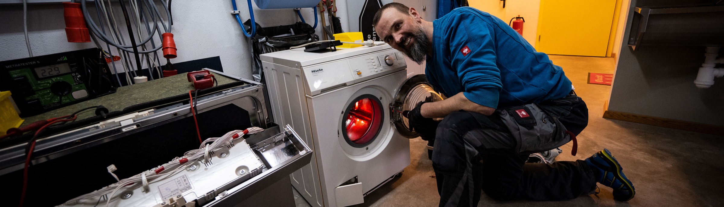 Josef Greil in seiner Werkstatt bei der Reparatur einer Waschmaschine